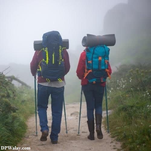 two people walking on a trail in the fog