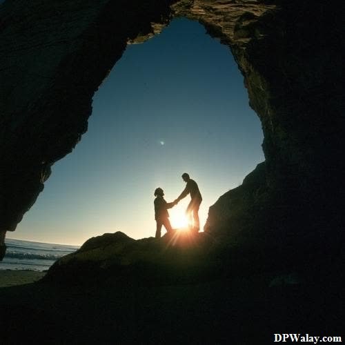 a man standing in a cave looking out at the sun couple romantic dp 