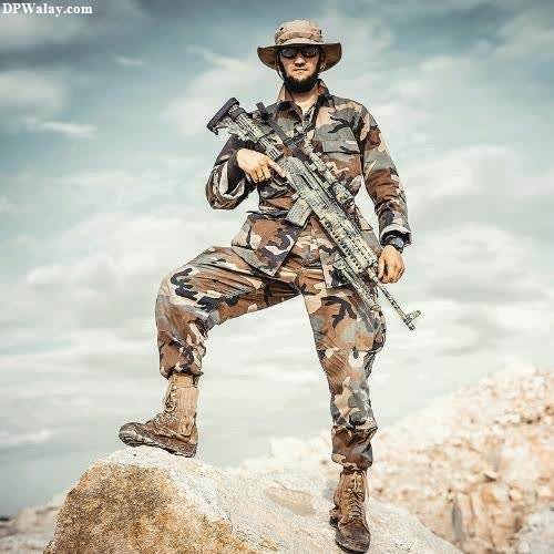 a soldier in camouflage gear standing on a rock