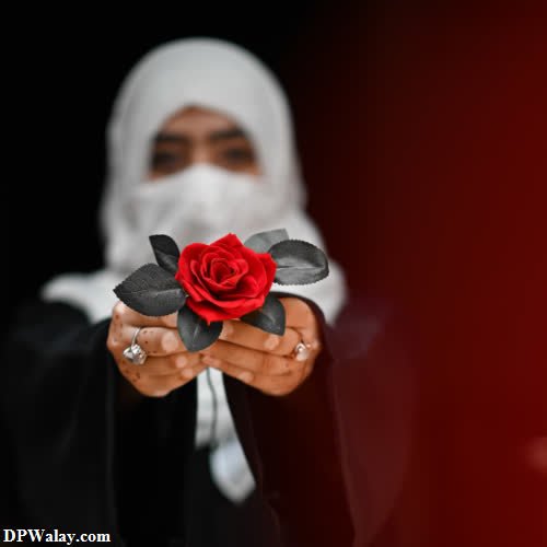 a person in a white tuk holding a red rose