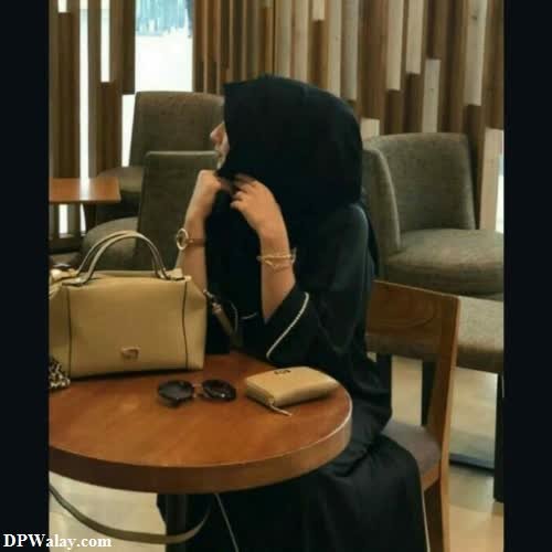 a woman sitting at a table with a purse