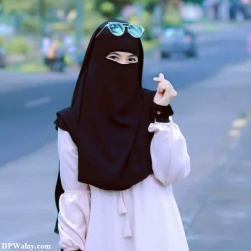 a woman in a black hina is walking down the street dp for girls hijab 