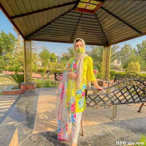 Hijab Girl DP - a woman in a yellow and green outfit standing on a patio