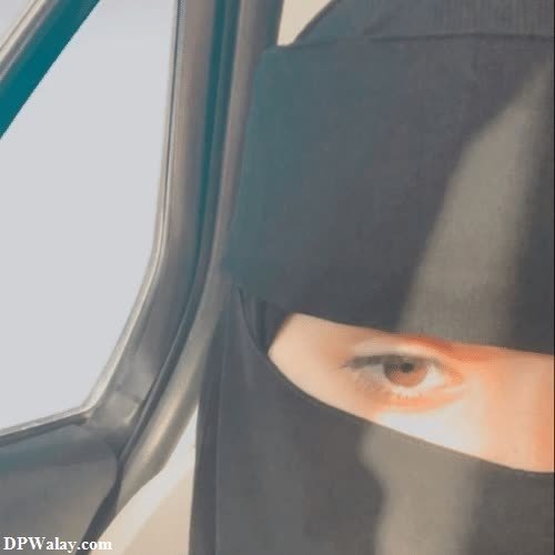 a woman in a black hoodie looking out the window 