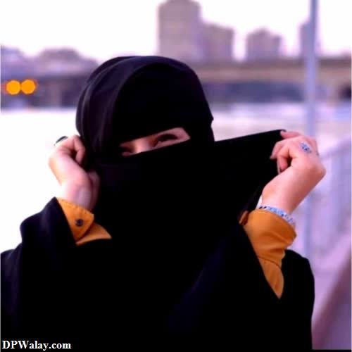 a woman in a black hoodie is holding her head