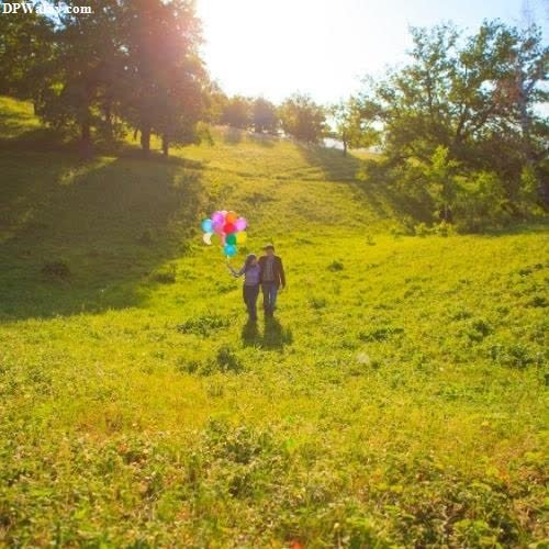 a person walking through a field with a kite dp images couple