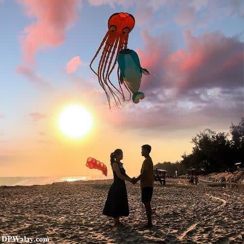 a couple flying a kite on the beach 