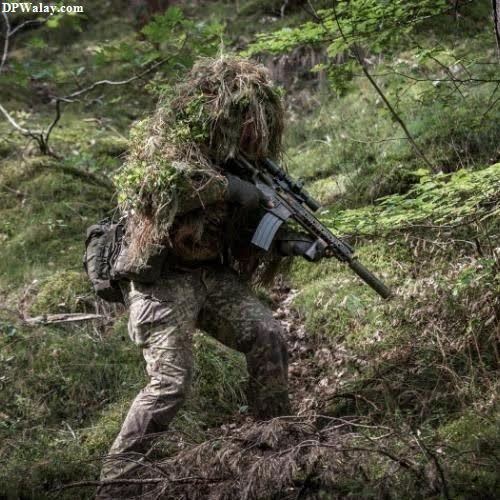 a soldier in camouflage gear walking through the woods 