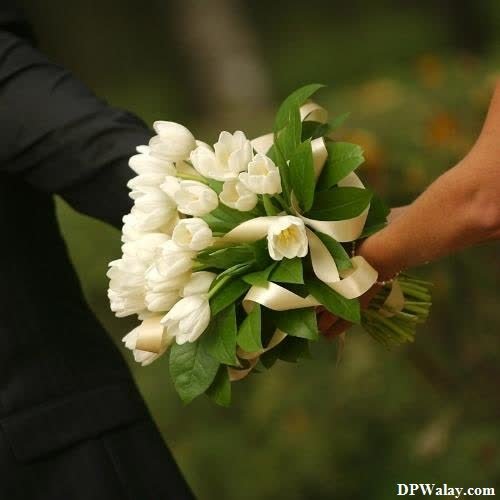 a person holding a bouquet of white flowers 