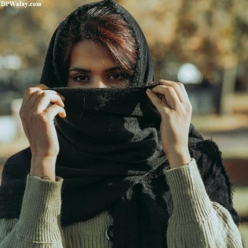 a woman in a scarf is holding her head
