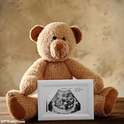 a teddy bear sitting next to a picture frame