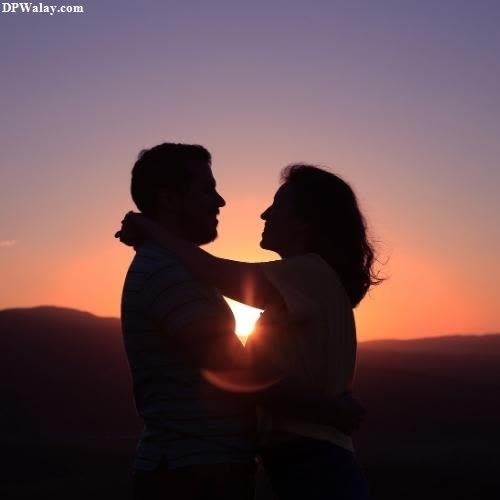 a couple is silhouetted against the setting sun 