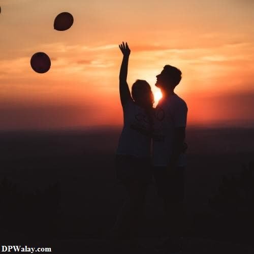 a couple playing with a ball at sunset