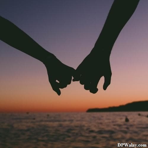 two people holding hands at sunset 