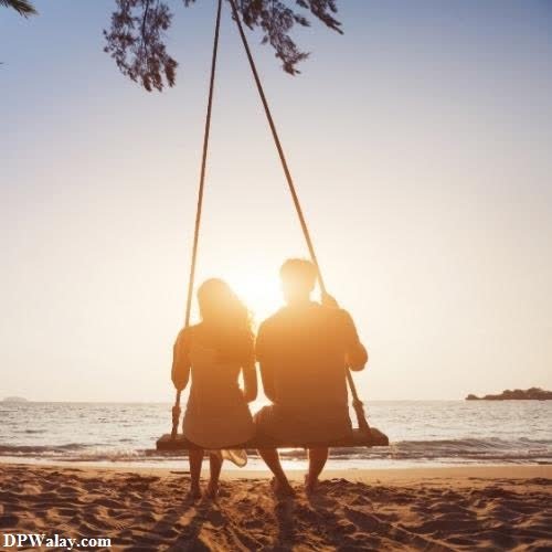 two people sitting on a swing at the beach romantic couple dp