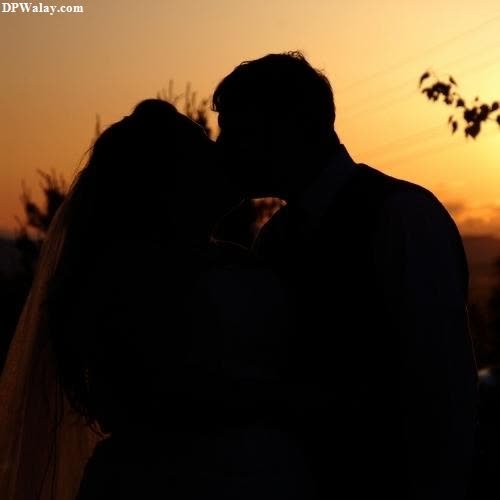 Romantic DP - a silhouette of a bride and groom kissing at sunset