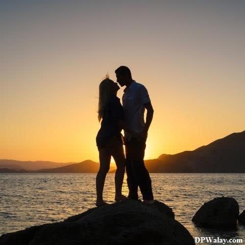 a couple kissing on the rocks at sunset