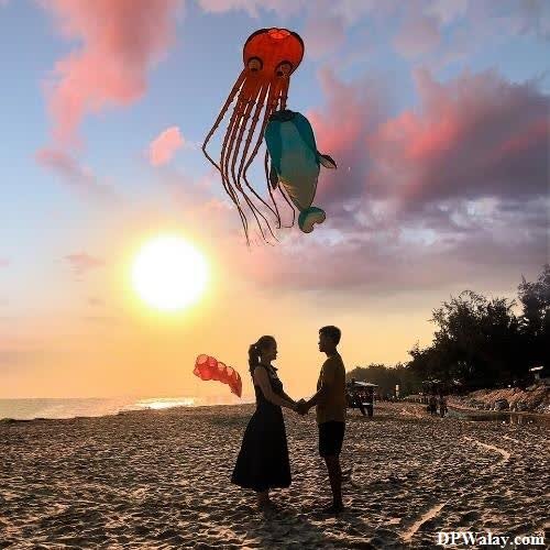 Romantic DP - a couple flying a kite on the beach