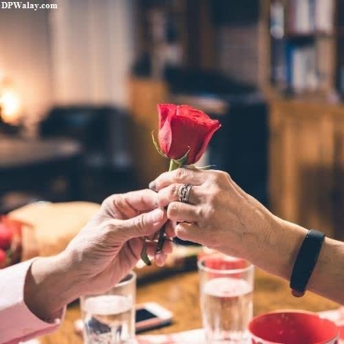 a man and woman are holding hands over a rose romantic dp pic