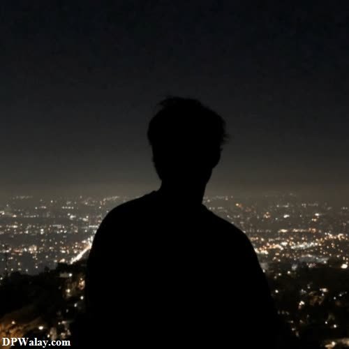 a man looking at the city lights from a hill sad black dp for whatsapp