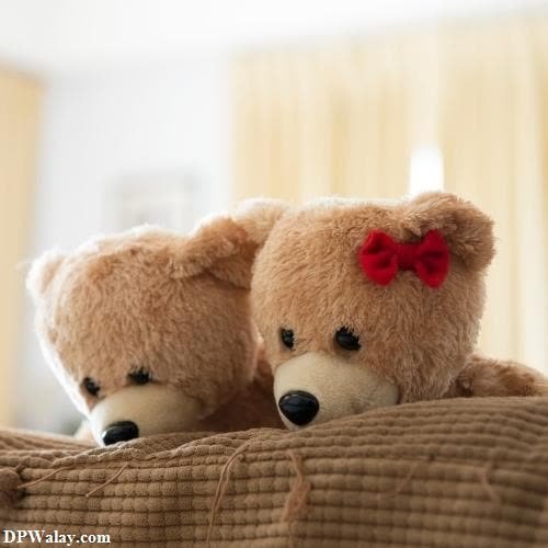 two teddy bears sitting on a bed