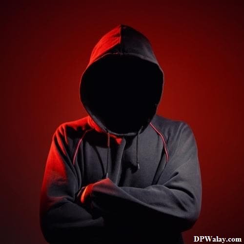 a man in a hoodie standing with his arms crossed 