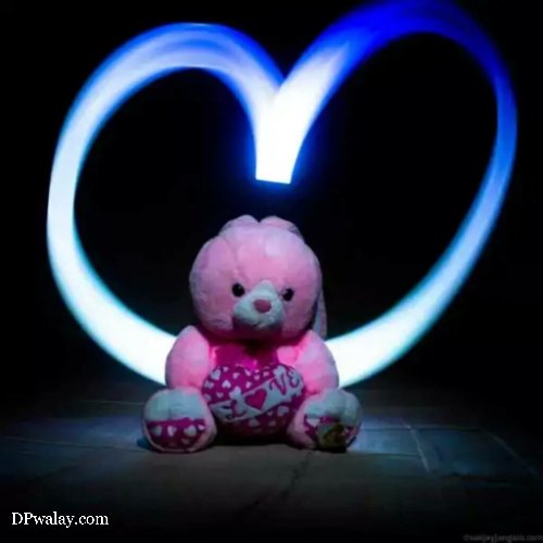 a teddy bear sitting in front of a heart