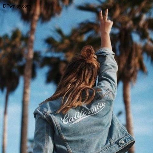 a woman wearing a denim jacket with the word california on it