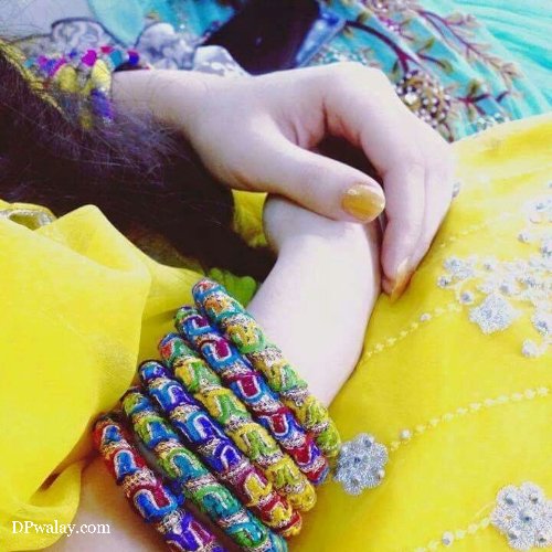 woman wearing yellow dress and colorful bracelet girls hand dp
