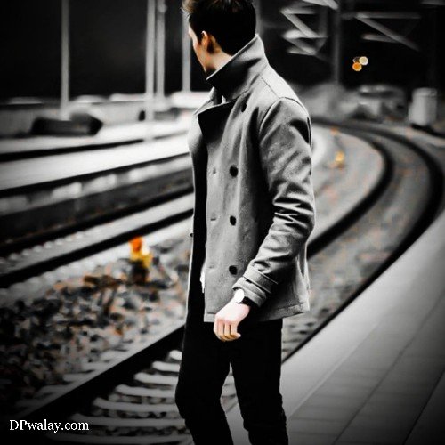 man in coat standing on train platform